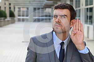 Businessman trying to hear a gossip