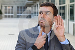 Businessman trying to hear a gossip photo