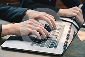 The businessman typing a laptop`s keyboard in the office. the concept of programming, development, software, technology and busine