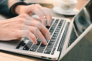 The businessman typing a laptop`s keyboard in the office. the concept of programming, development, software, technology and busine