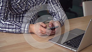 Businessman typing sms on telephone.