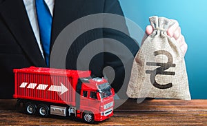 Businessman with ukrainian hryvnia money bag and truck. Income of the transport business and transport of goods. High salaries for