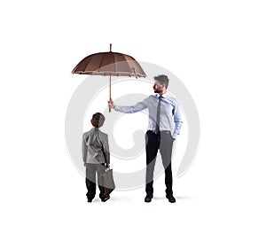 Businessman with umbrella that protect a child. Concept of young economy and startup protection