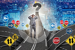 Businessman in uncertainty concept on road intersection crossroa photo