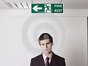 Businessman Under Exit Sign