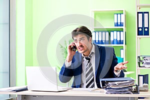 The businessman unhappy with excessive work sitting in the office