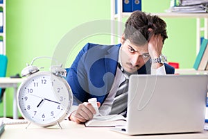 The businessman unhappy with excessive work sitting in the office