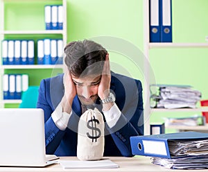 Businessman unhappy with excessive work sitting in the office