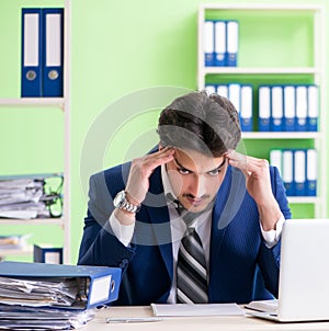 Businessman unhappy with excessive work sitting in the office