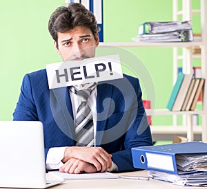 Businessman unhappy with excessive work sitting in the office