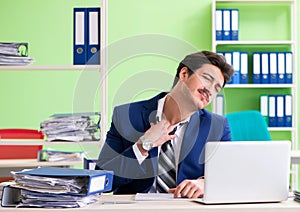 Businessman unhappy with excessive work sitting in the office