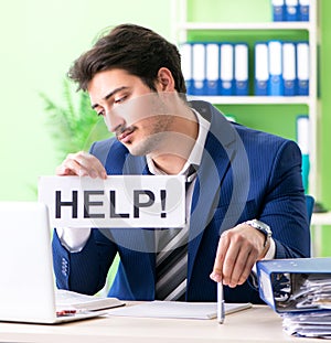 Businessman unhappy with excessive work sitting in the office