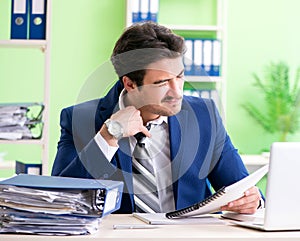 Businessman unhappy with excessive work sitting in the office