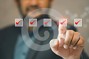 Businessman use pen to tick correct sign mark in checkbox for quality control