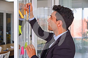 businessman use post it notes on the glass in meeting room