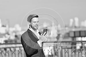 Businessman use smartphone with smile. Happy man with mobile phone on sunny terrace. Great business news. Communication