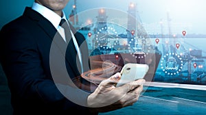 A businessman uses a cellphone for logistic network distribution and smart transportation, concept of networking intelligent