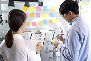 Businessman uses a pen in his hand to write a note on a notepad