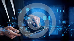 Businessman using tablet device for digital data analysis and visualization in modern office environment with graphs