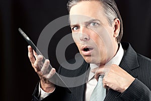 Businessman Uses Tablet, Looks To Camera Concerned