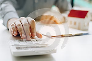 Businessman using calculator calculate budget about house contract mortgage in the office room photo