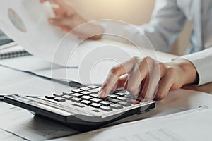 businessman using calculator for calculate budget on table in of