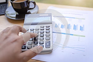 Businessman using calculator for calculating with finance paper, tax, accounting, Accountant concept