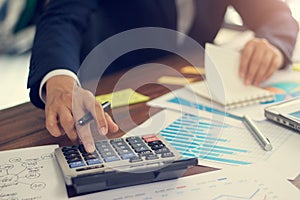 Businessman using calculator to calculate budget and analyzing sales data and growth graph, Payments, Business financing