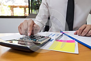 Businessman is using a calculator to calculate the numbers