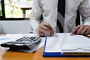 Businessman is using a calculator to calculate the numbers
