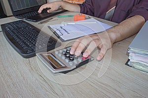 Businessman using a calculator to calculate the numbers