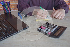 Businessman using a calculator to calculate the numbers