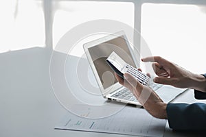 Businessman using a calculator to calculate numbers on a company's financial document