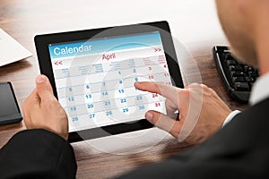 Businessman using calendar on digital tablet