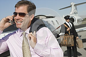 Businessman Using Cell Phone At Airfield photo