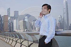 Businessman Using Cell Phone On Bridge