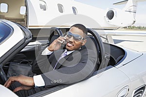 Businessman Using Cell Phone In Convertible
