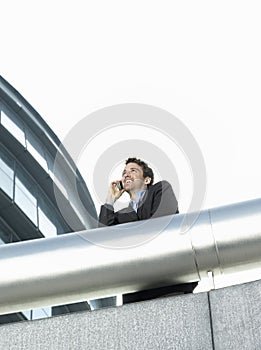 Businessman Using Cell Phone Outside Office Building