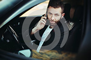 Businessman using a cellphone in his car