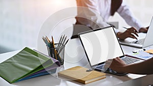 Businessman using computer laptop during meeting on white table.