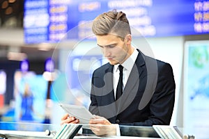 Businessman Using Digital Tablet In Airport Departure Lounge