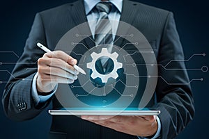 Businessman using digital tablet with gear icon for technology and engineering solutions concept