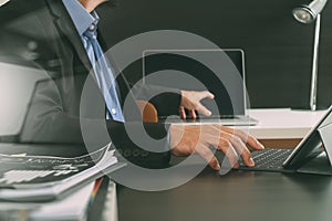 businessman using digital tablet and laptop computer and document in modern office