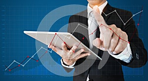 Businessman using digital tablet and pointing finger on graph diagram. Break even point, business growth, investment and finance c