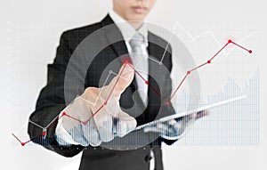 Businessman using digital tablet and pointing finger on graph diagram. Break even point, business growth, investment and finance c