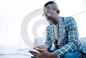 Businessman using digital tablet sitting in the office waiting room