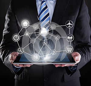 Businessman using digital tablet with various virtual icons
