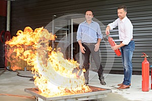 Businessman using fire extinguisher during fire training