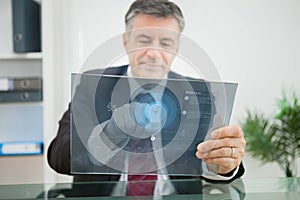 Businessman using futuristic touchscreen to view data