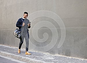 Businessman using his cellphone while walking in the city. Man using cellphone while commuting to work. Using internet